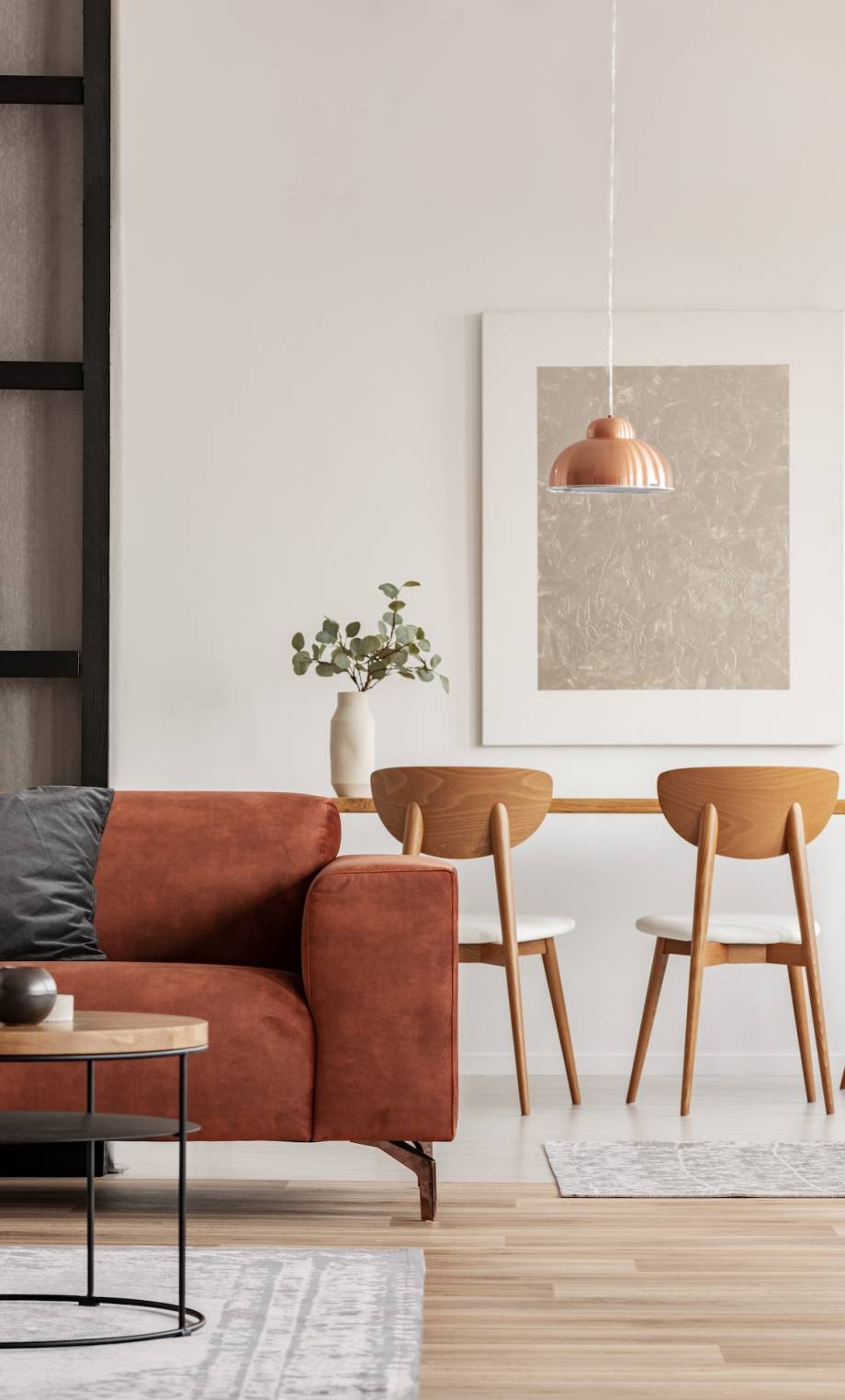 Open plan living and dining room interior with long table with chair and brown velvet settee